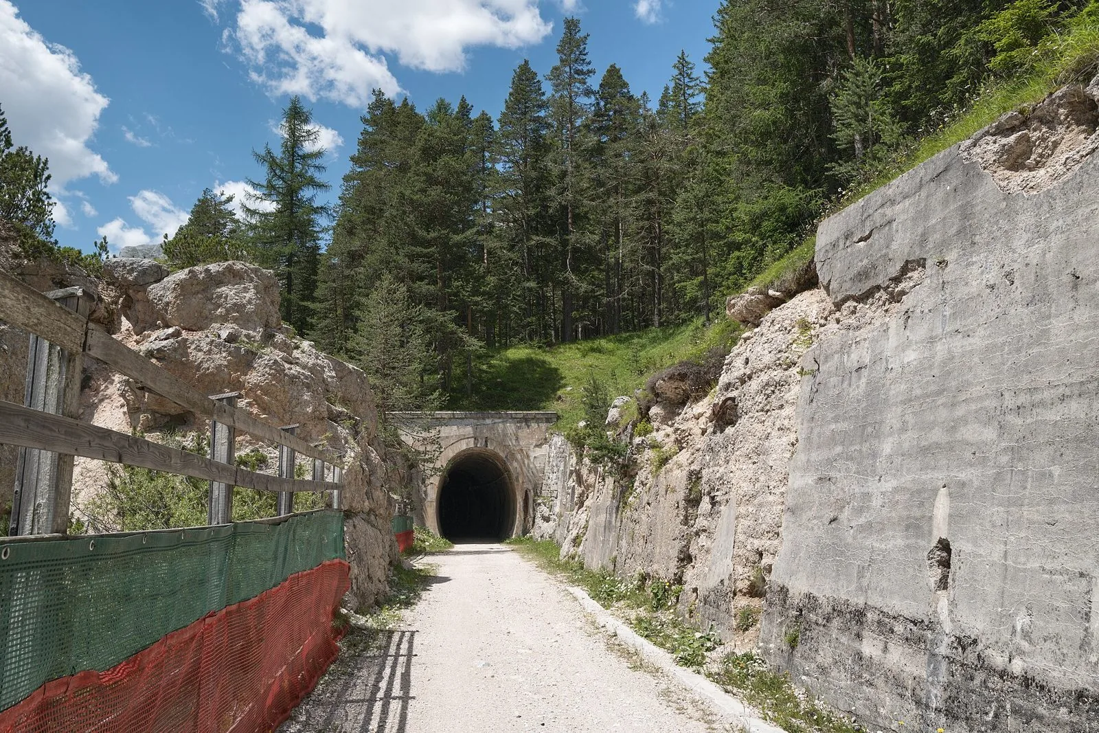 La pista ciclabile Lunga Via delle Dolomiti a Cortina d'Ampezzo con una galleria della vecchia ferrovia tra i pini